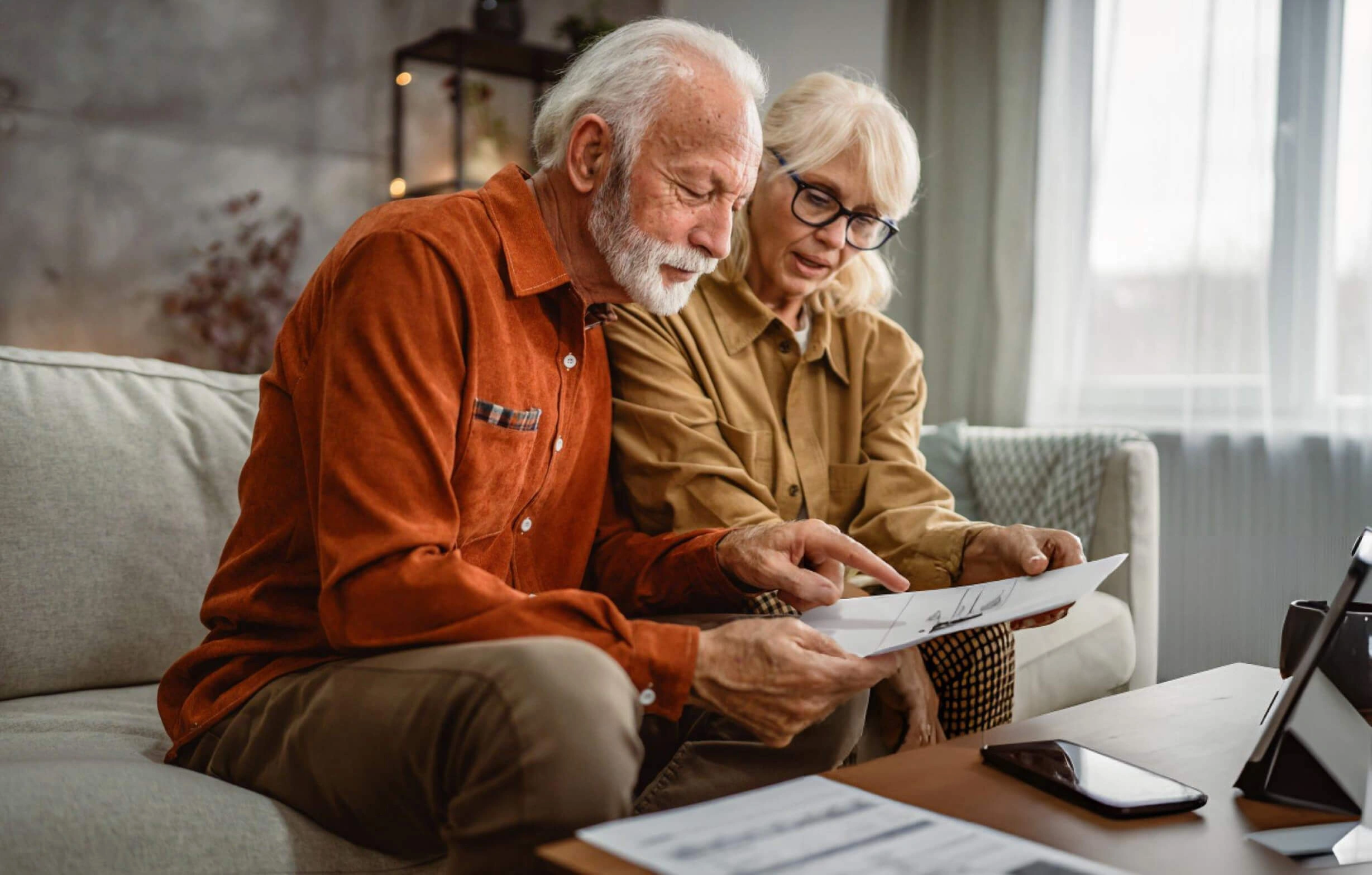 Older couple reading paperwork together at home